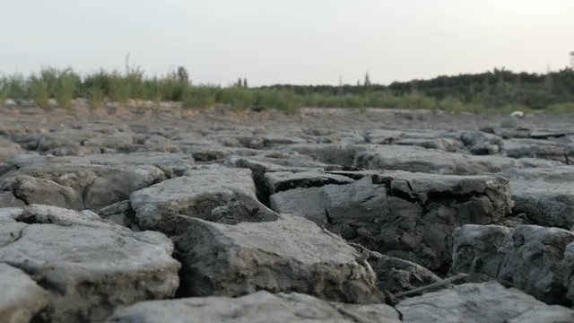 Man walking alone through dry deserted land with cracked soil

