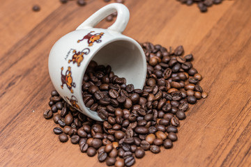 Coffee cup and coffee beans on a wooden background.