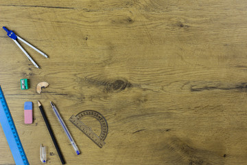 A flat lay photo of stationery set: pencil, rubber, sharpener, compass, protractor, ruler and etc....