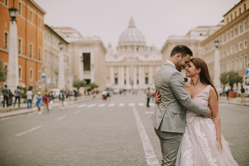 Naklejka premium Young wedding couple by Saint Peter cathedral in Vatican