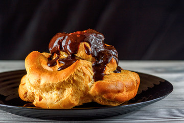 home eclair on a plate on a wooden background 