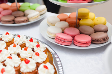 snacks, macaroons, tartlets with various fillings on white table