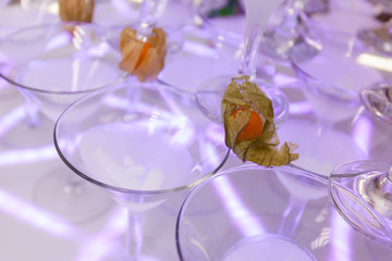 Pyramid from champagne glasses with physalis at the wedding