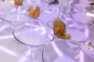 Pyramid from champagne glasses with physalis at the wedding