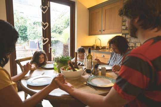 Family Praying Before Having A Meal