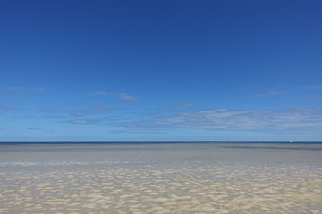 Fototapeta na wymiar 青い空と遠浅の砂浜のビーチ