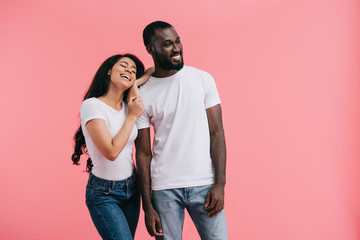 Naklejka premium smiling young african american couple looking away isolated on pink background