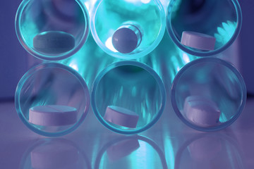 Tabletten mit Glasgefäß im Gegenlicht 