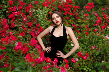 Obraz na płótnie Canvas Portrait of beautiful young woman in the rose garden, spring time, rose flowers blossoms.