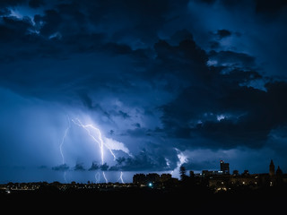 Fondo con cielo nocturno con nubes de tormenta, rayos y relampagos en tonos azulados.Noche de...
