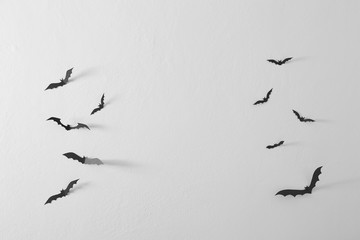 Black paper bats flying wall white