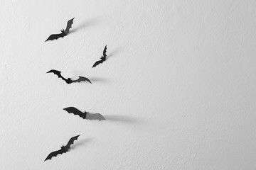 Black paper bats flying wall white