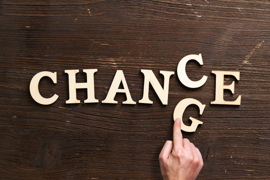 Hand changes one of six letters, turning the word "change" to "chance" 