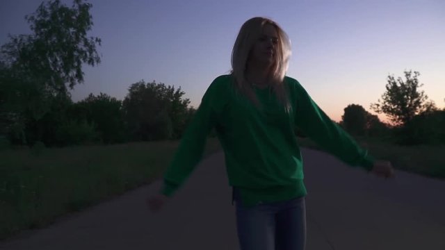Blond girl is running along the road