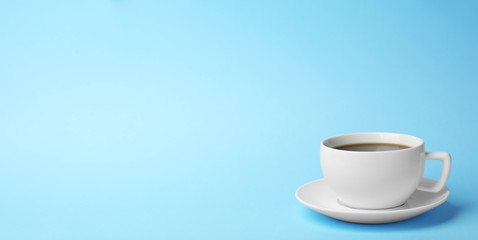 White ceramic cup with hot aromatic coffee on color background