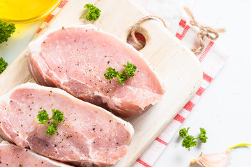 Pork meat steak on white top view.