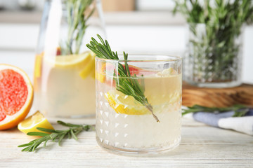 Refreshing grapefruit cocktail with rosemary on table