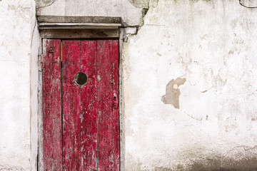Red wooden door, white stucco and cement wall concrete backgrounds textured.