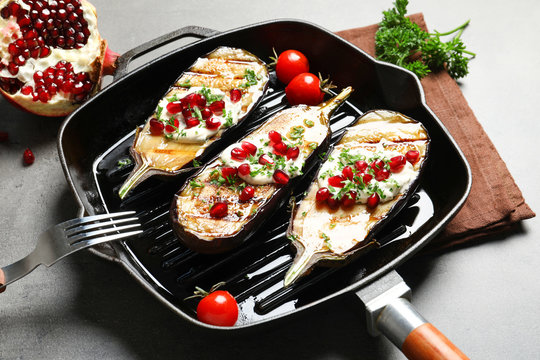 Grill pan with fried eggplants on table