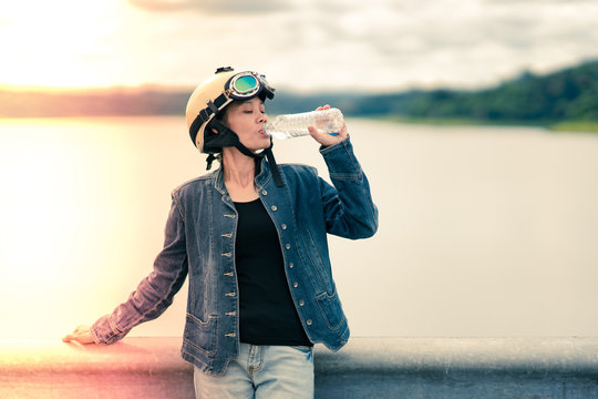 Women tourist drinking water afer travel by motorcycle or motorbike