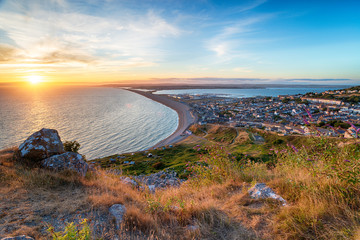 Stunning sunset over the causeway on the Isle of Portland on Dorset's Jurassic Coastline, looking back towards Weymouth © Helen Hotson