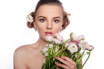 ..Young beautiful woman with a bouquet of tender spring flowers over white background, ranunculus.