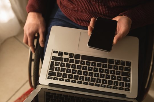 Disabled man using mobile phone at home