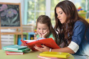 Portrait of mother and daughter reading books