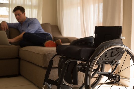Disabled man using laptop in living room