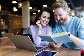 Attractive students learning together in coffee shop