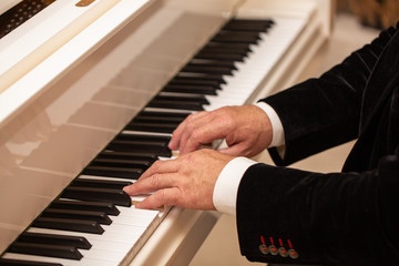 Fototapeta na wymiar close up of male hands playing piano. Horizontal shape