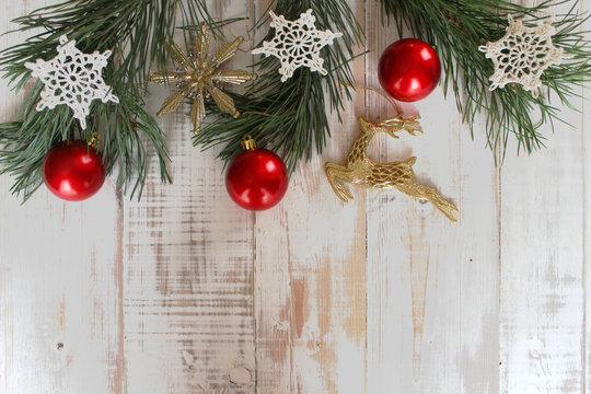 Pine branches, red Christmas balls, snowflakes crocheted on old white background. The concept of the celebration. Christmas and New Year.