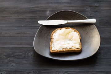 sandwich with buttered butter and knife on black