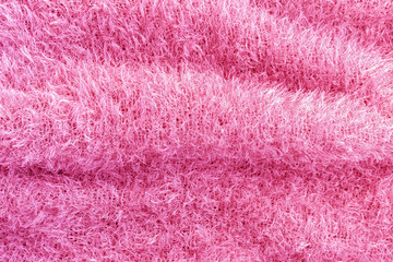 Background of soft, fluffy knit fabric. Pink knitted texture.