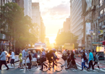 Man riding bike crosses intersection with crowds of people on 23rd Street and 6th Avenue in...
