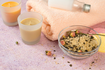 Sea salt with rose petals, scented candles, a gentle terry towel and a bottle of coconut oil on a pink background. SPA skin care for face and body. 