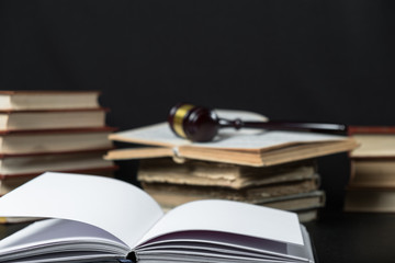 Judge gavel beside pile of books on wooden background