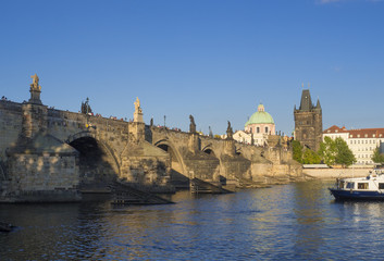 Obraz premium View of Charles Bridge in Prague, Czech Republic. Gothic Charles Bridge is one of the most visited sights in Prague. Architecture and landmark of Prague, golden light, sunny summer day