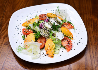 Summer salad of vitamin arugula and tomato served on plate. Vegetable salad rich in vitamin. Spare an animal, eat a vegetable