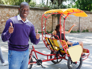 Portrait of African American driver of pedicab offering touristic tour