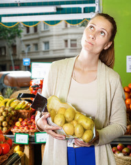 Obraz premium Portrait of woman who is choosing potatos in the market.
