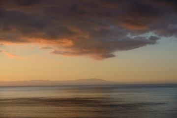 Fototapeta na wymiar Dark cloud over ocean in afterglow between islands of Canary.