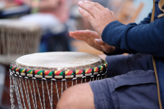 Hands of a musician playing on an African djembe drum, at a concert of percussion instruments