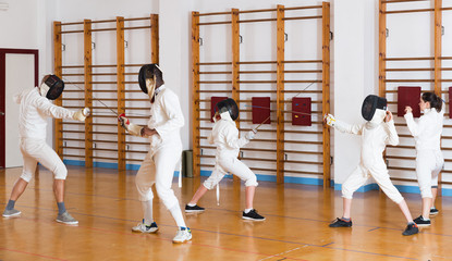 Young fencers training with coach