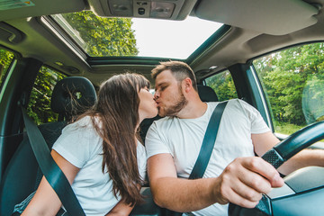 couple kissing in car while driving