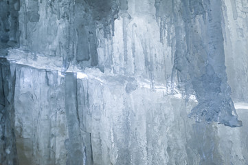 Crystal clear icicles hanging down in frozen cave, Jagala Waterfall, Estonia. Beautiful winter wallpaper. Close-up.