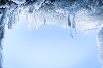 Close up of Icicles against a blue sky background. Frozen waterfall. Copy space, soft focus.