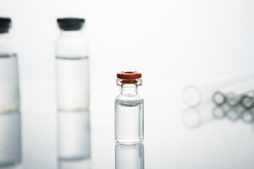 Group of vials with medication on blue methacrylate table.