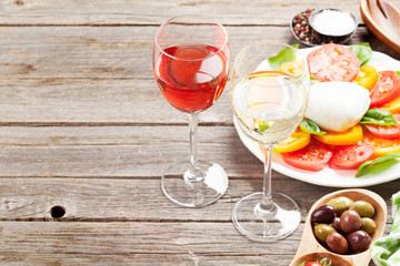 White and rose wine glasses with caprese salad