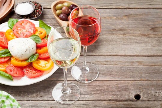 White and rose wine glasses with caprese salad